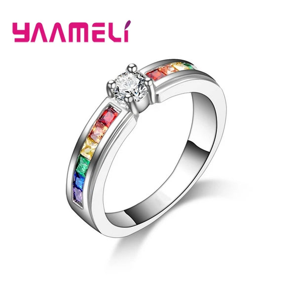Bague de fiançailles en argent sterling avec un diamant central entouré d'accents de pierres colorées.