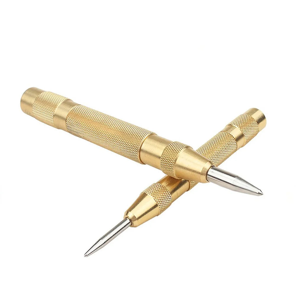 A gold-colored spring-loaded automatic center punch tool with a sharp point.