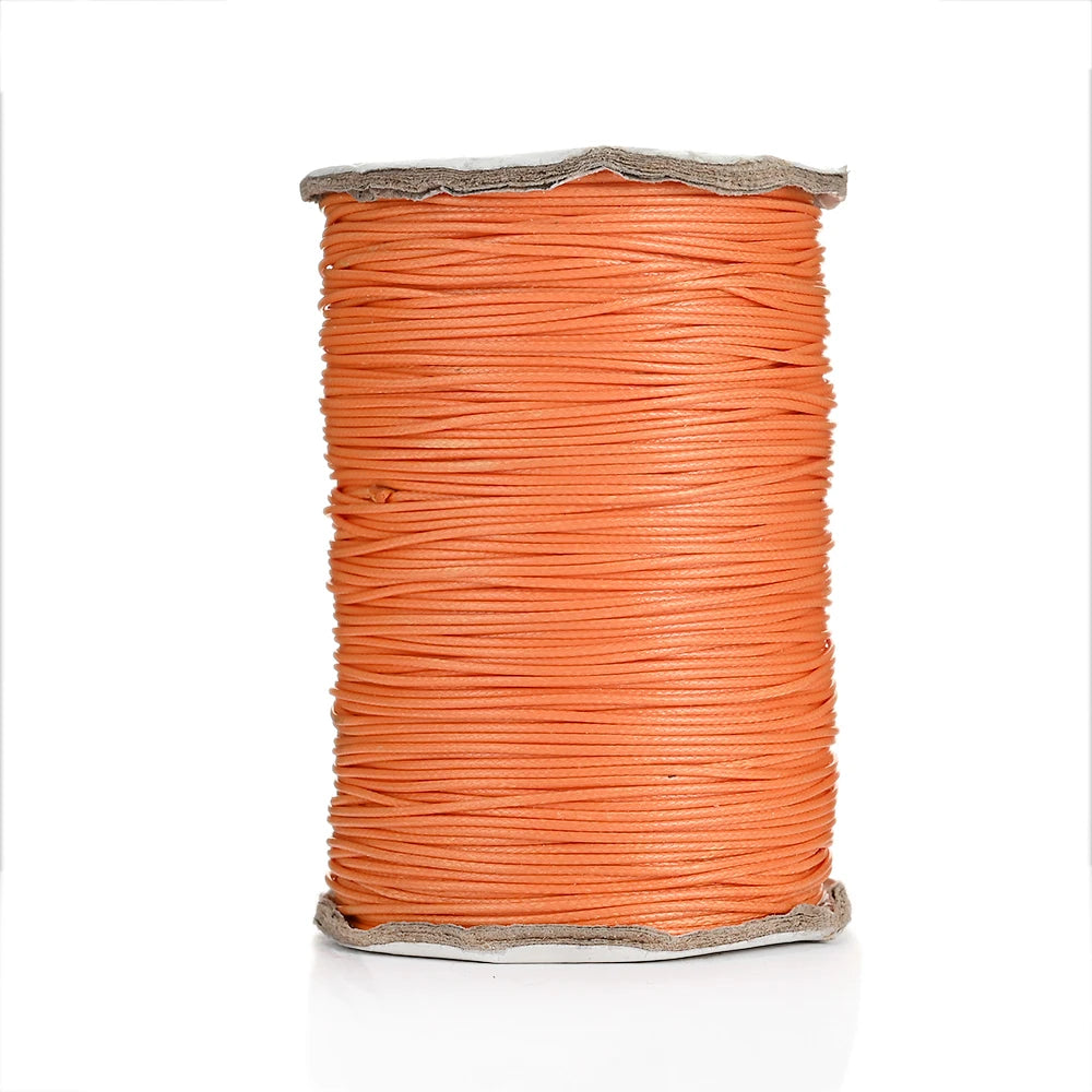 A spool of bright orange waxed cotton cord used for jewelry making.