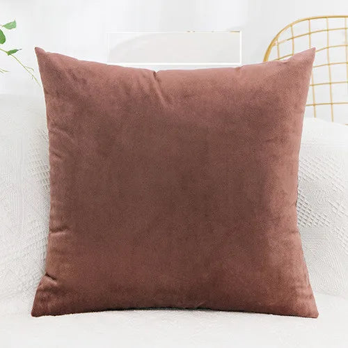 A square, solid brown velvet decorative cushion cover resting on a white sofa.