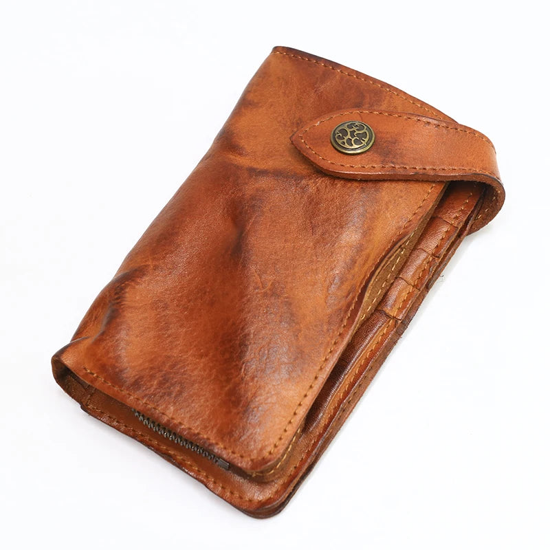 A brown vintage cowhide leather bi-fold wallet with a brass-colored snap closure.