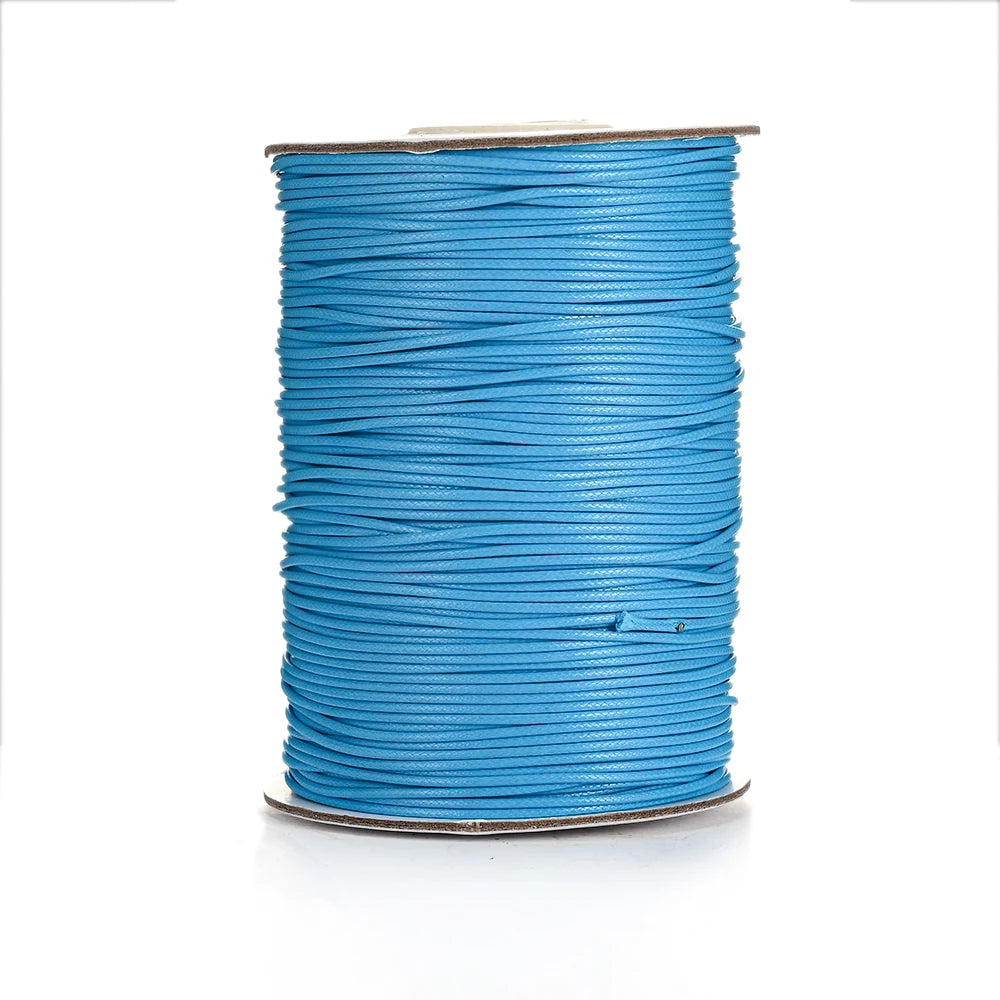 A spool of bright blue waxed cotton cord used for jewelry making.