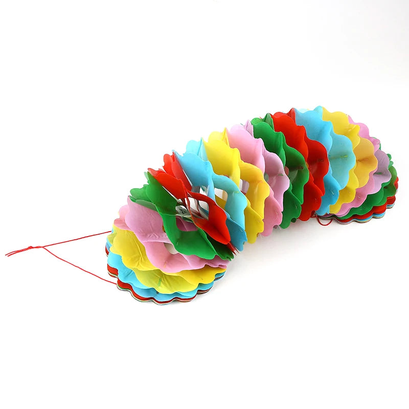 A colorful magic trick prop set featuring a bag and flower, with multiple layered petals in red, orange, yellow, green, and b