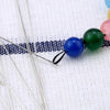 Stainless steel beading needles with colorful beads on a white background