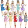 A collection of various fashion dolls and accessories in colorful dresses and outfits.