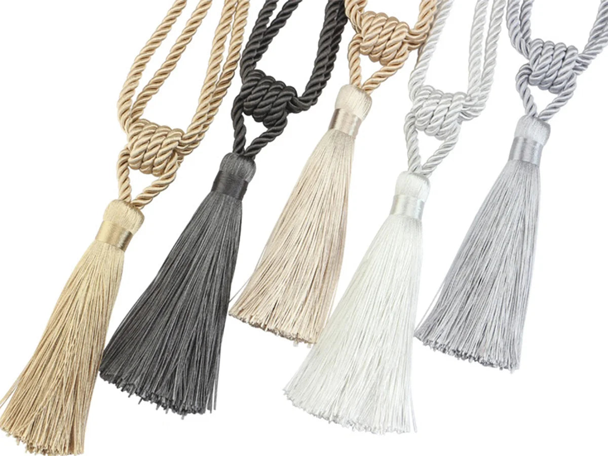 A set of two elegant tassel curtain tiebacks in natural and gray tones.