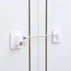 A white child safety cabinet lock with a key or digital code is mounted on a white door.