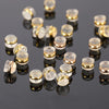 A collection of silicone rubber ear back stoppers with copper rings scattered on a dark surface.