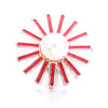 A sunburst design of red metal snap buttons with a central pearl, used for jewelry making.