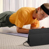 Eine Person nutzt einen tragbaren Full-HD- externen Monitor beim Yoga auf einer Matte.