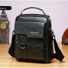 Schwarze Leder-Crossbody-Tasche mit goldener Schnalle auf einer Holzoberfläche.