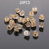 20 pieces of silicone rubber ear back stoppers with copper rings scattered on a dark surface
