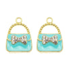 A set of six gold-toned handbag charm pendants featuring light blue enamel and sparkling clear crystals.