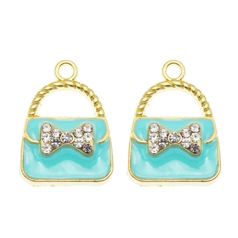 A set of six gold-toned handbag charm pendants featuring light blue enamel and sparkling clear crystals.