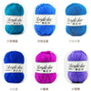 A collection of soft acrylic yarn balls in various colors including turquoise, blue, purple, and pink.