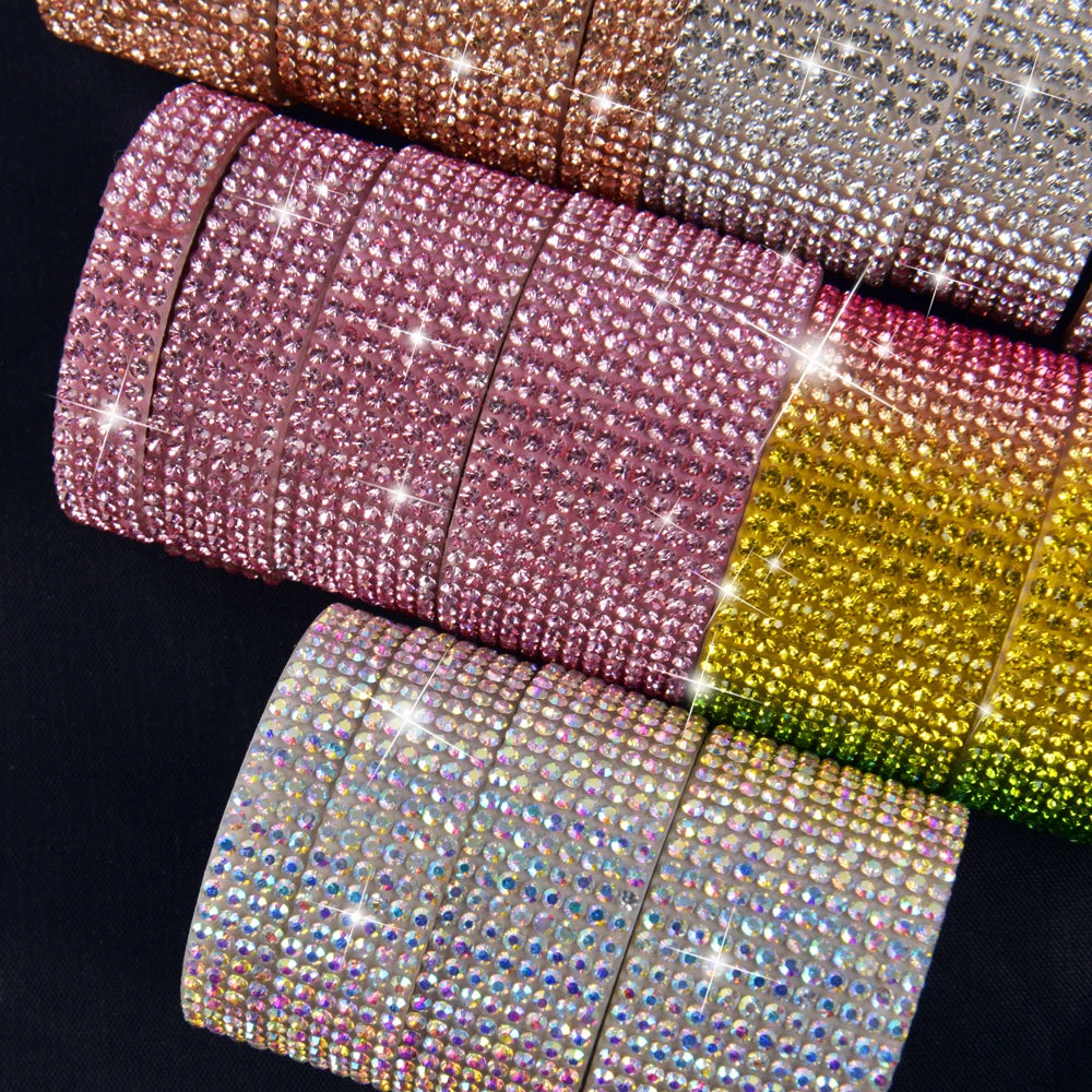 A close-up of various colored crystal rhinestone ribbon stickers arranged in a row.