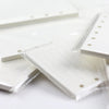 A close-up view of loose leaf notebook refill paper sheets with perforated edges and ruled lines.