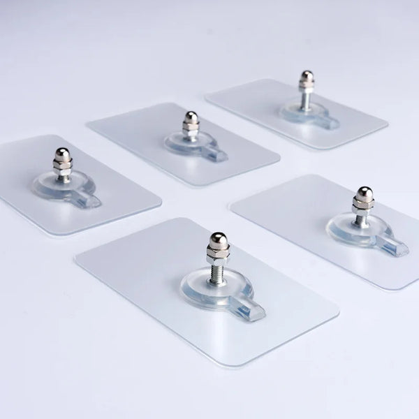Several transparent self-adhesive wall hooks with silver mounting posts are displayed on a white surface.