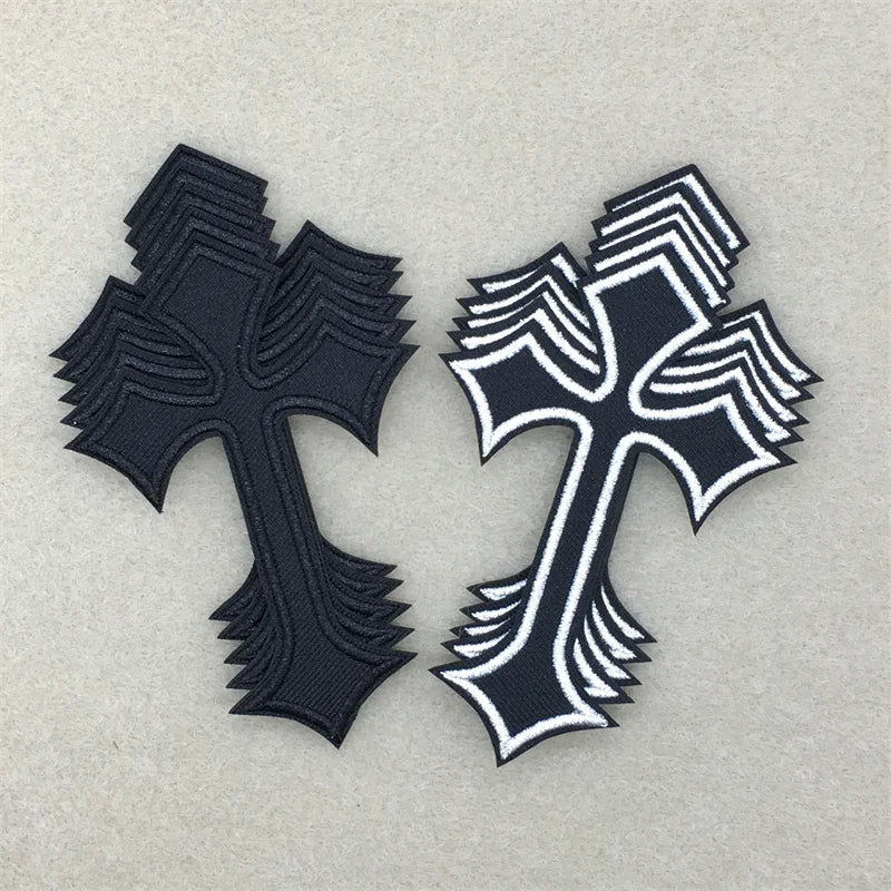 A set of ten embroidered cross iron-on patches in black and white on a light gray background.