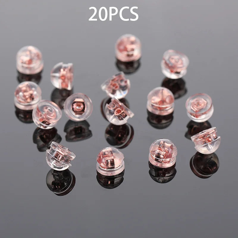 20 pieces of clear silicone rubber ear back stoppers with copper rings displayed on a dark surface.