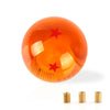 An orange, spherical gear shift knob with a star design is shown against a white background.