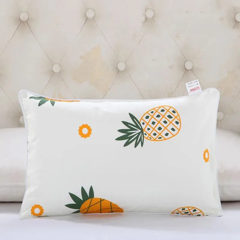 A white cartoon pillowcase featuring orange and green tropical fruit designs like pineapple and orange slices.