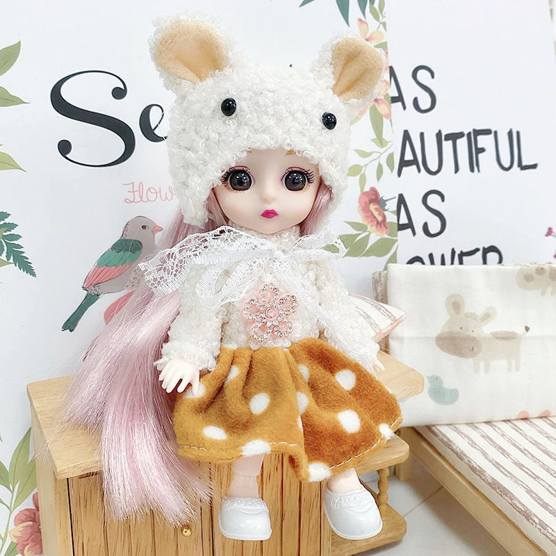 A white fluffy fashion doll with pink hair and an orange polka dot skirt is displayed next to a small bird.