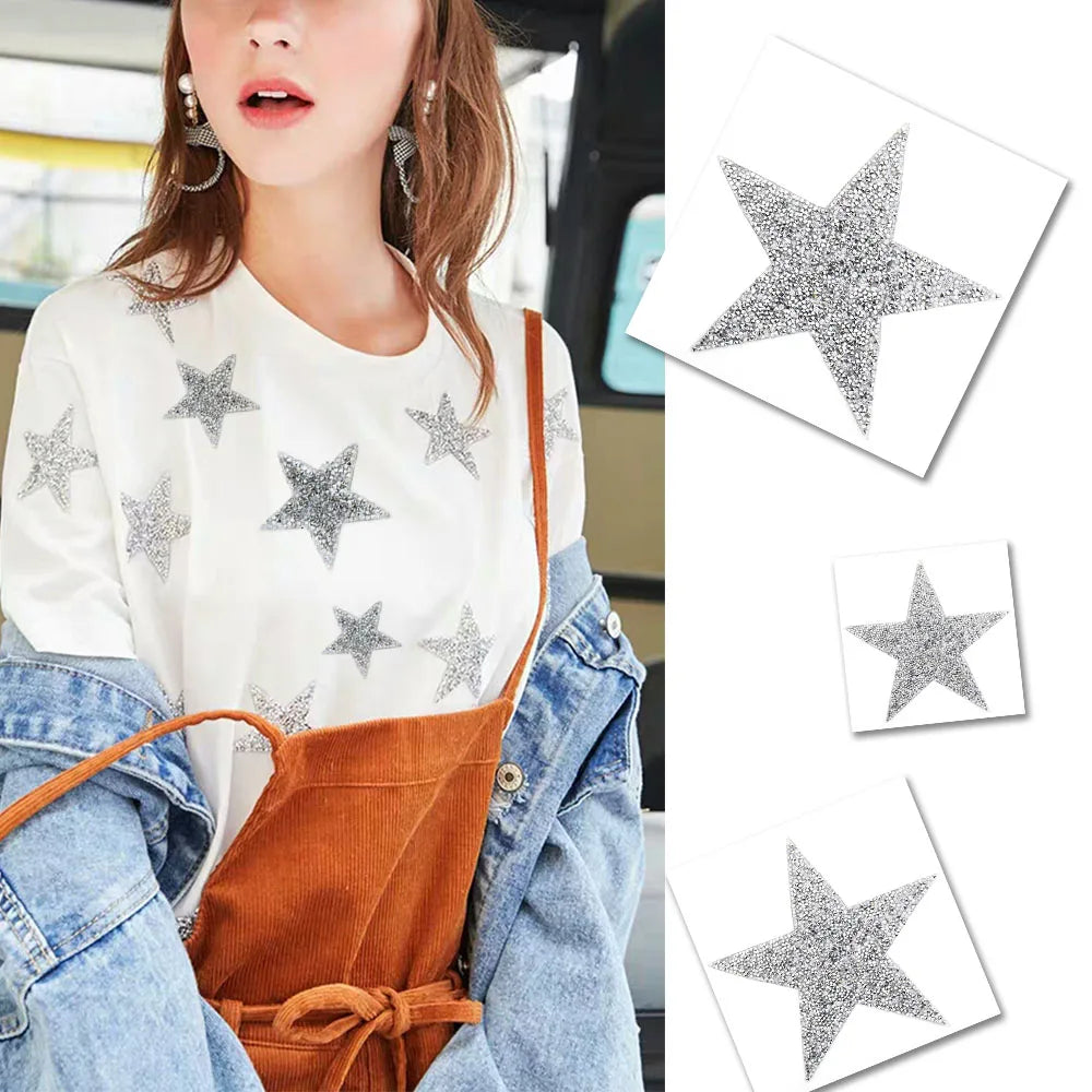 A woman wearing a white top and denim jacket, holding glitter rhinestone star patches.
