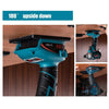 A blue and black cordless drill or power tool is shown upside down, mounted on a wall.