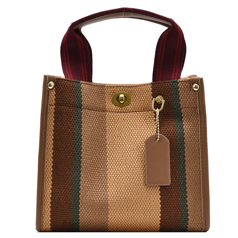 A brown canvas crossbody tote bag with vertical stripes and a maroon strap.