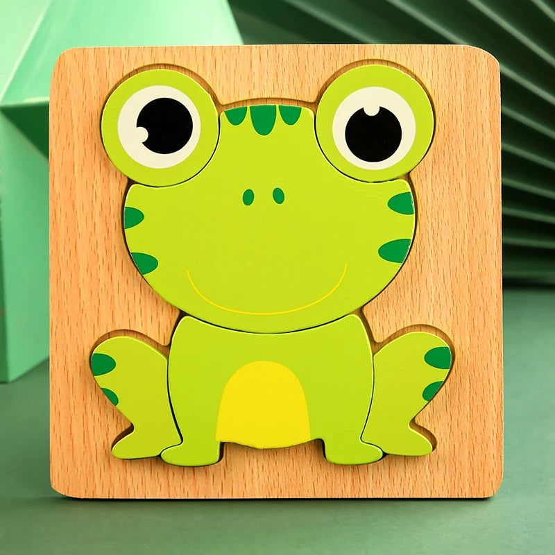 A wooden 3D frog puzzle set featuring a bright green frog with large eyes and yellow belly.