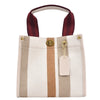A beige canvas crossbody tote bag with vertical stripes and a brown leather strap.