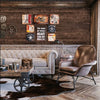 A dimly lit interior featuring rustic wood grain wallpaper on the wall, a leather armchair, and a wooden table.