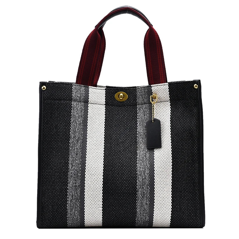 Black and white striped canvas crossbody tote bag with brown leather strap