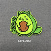 A bright lime green embroidered patch of a cute cat face with orange paws and a green body.