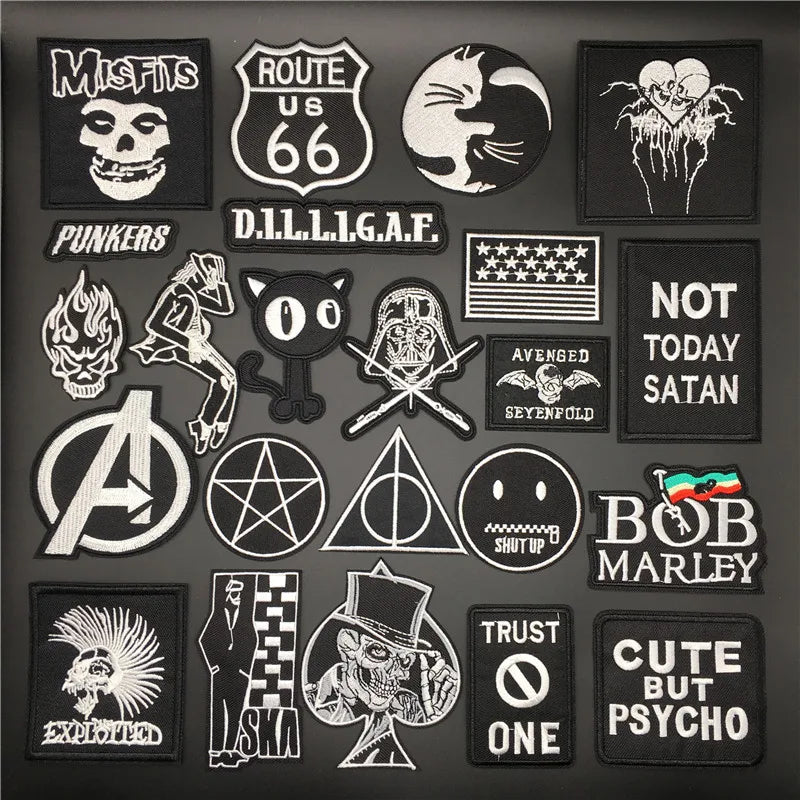 A collection of black embroidered punk skull patches and badges featuring various symbols, text, and imagery.