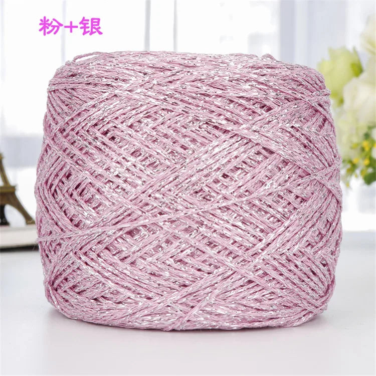 A ball of pink metallic silk crochet yarn with a shimmering silver thread for knitting and macrame.