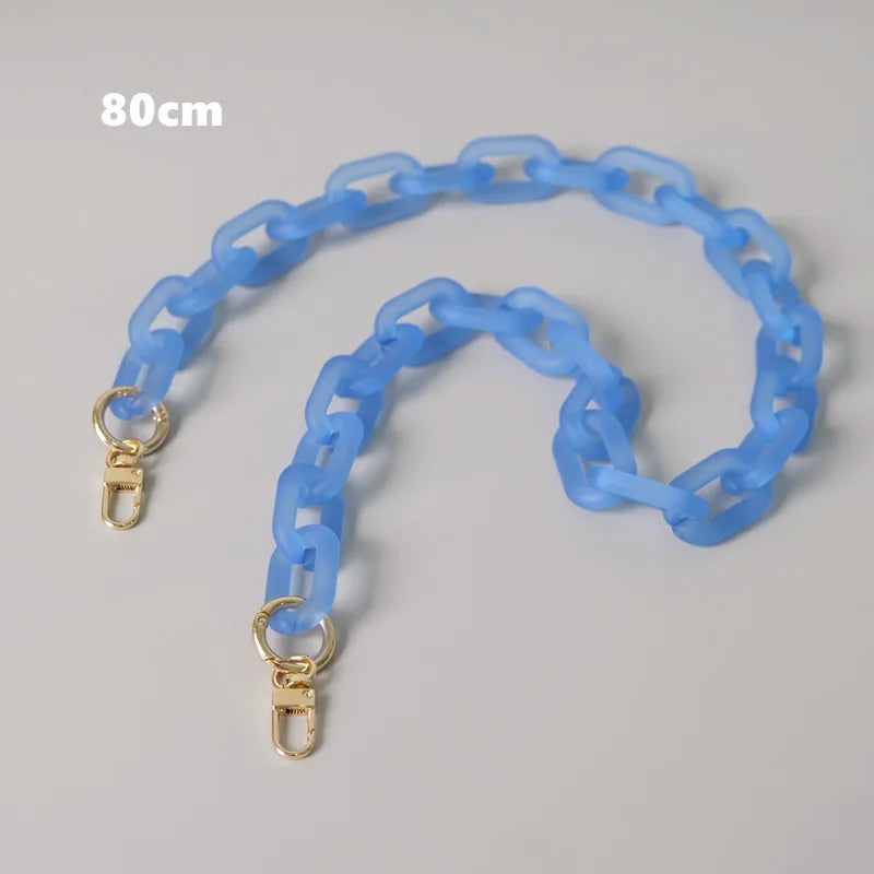Helles blaues abnehmbares Kettchenriemen für eine Tasche, flach vor grauem Hintergrund.