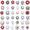 A collection of various 18mm metal snap buttons and decorative findings for jewelry making.