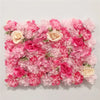 A dense wall panel of pink and light pink silk rose flowers for weddings and events.
