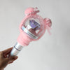 A hand holds a plush pink cover with a clear dome and purple crystal inside, designed for a SEVENTEEN official light stick.
