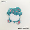 A light blue embroidered patch of a cute elephant face with pink accents and a white belly.
