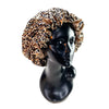 A black mannequin head wearing a patterned satin hair bonnet with ruffled edges.