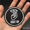 Black embroidered patch featuring a stylized skull and the text SHUT UP on a hand.