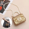 A golden glitter pouch bag is shown with a pearl chain strap, resting on a light pink background.