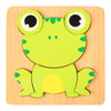 A wooden 3D frog puzzle set featuring a bright green frog with large eyes and yellow belly.