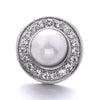 Silver snap button with a round, clear gemstone center surrounded by a halo of small clear stones