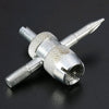 Kit de réparation de valve de pneu argenté à quatre voies avec tige filetée et embouts spécialisés.