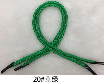 A green multi-color polypropylene gift string rope tied in a loop and crossed to form an 'X' shape.