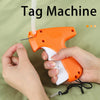 A hand is holding an orange and white tag machine device with a white tag being attached.